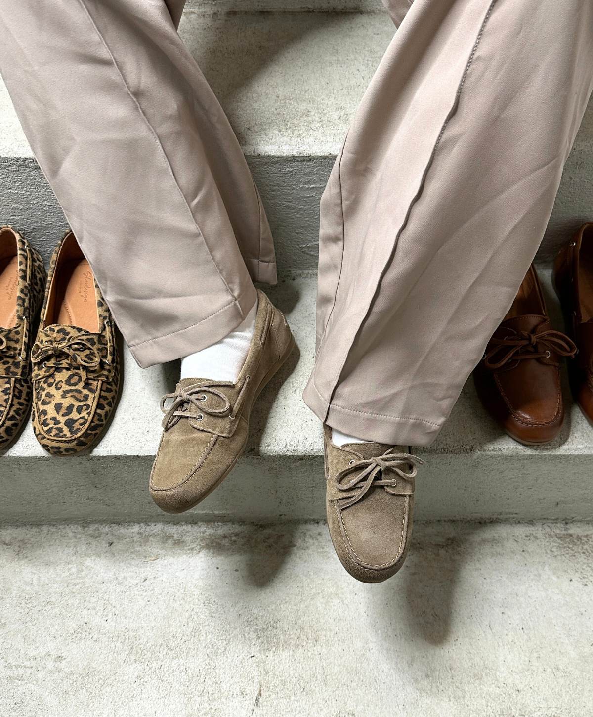 To par beige sejlersko fra Shoedesign Copenhagen på en trappe, flankeret af et par leopardmønstrede og et par brune loafers.