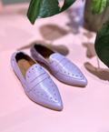 Lilla loafers fra Shoedesign Copenhagen med nitter på en lyserød baggrund.