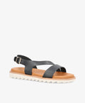 Sort lædersandal fra Shoedesign Copenhagen med krydsrem og justerbar spænde, flad sål i hvidt gummi.
