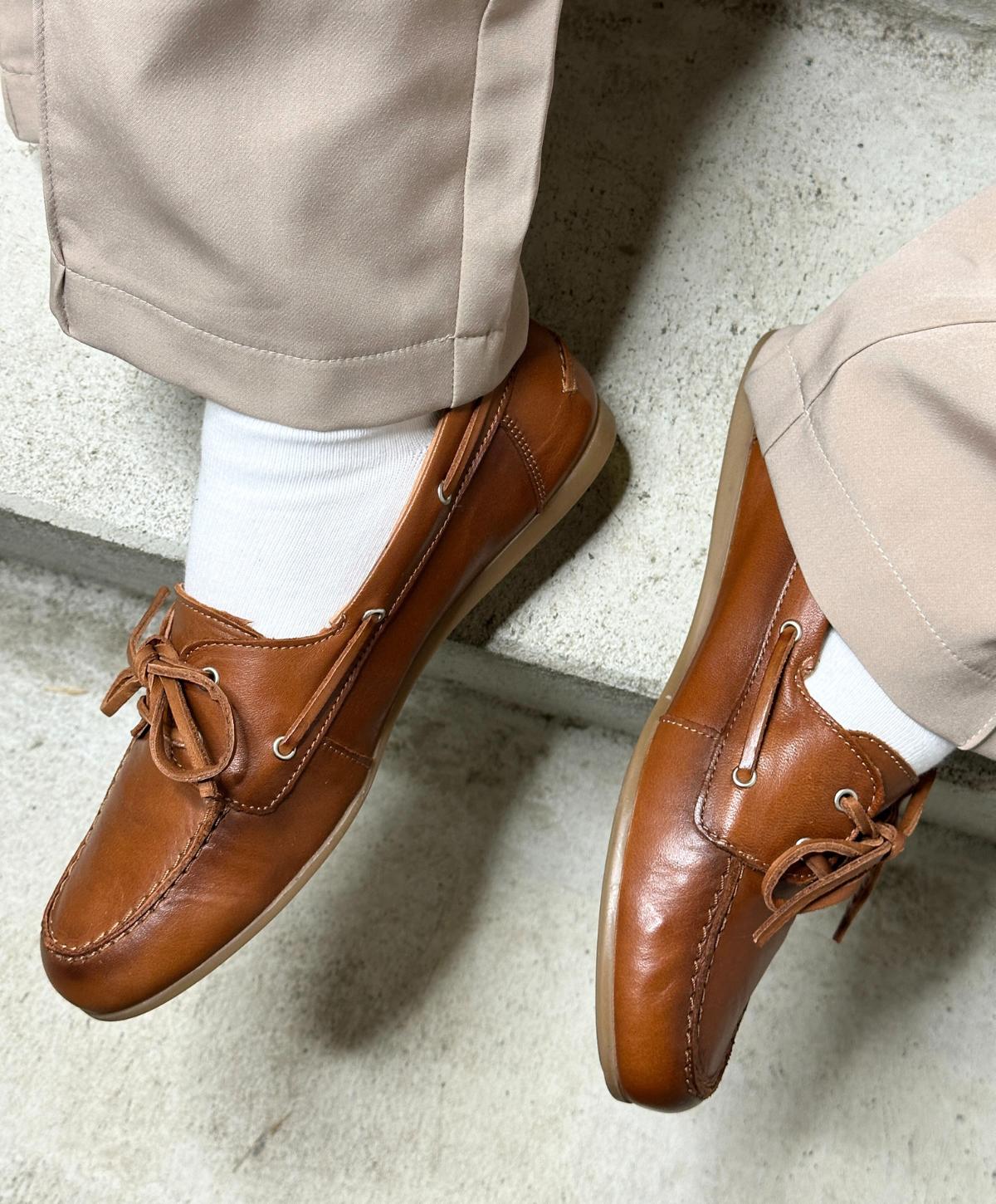 Brune lædersko fra Shoedesign Copenhagen med snørebånd, båret af en person med beige bukser og hvide sokker.