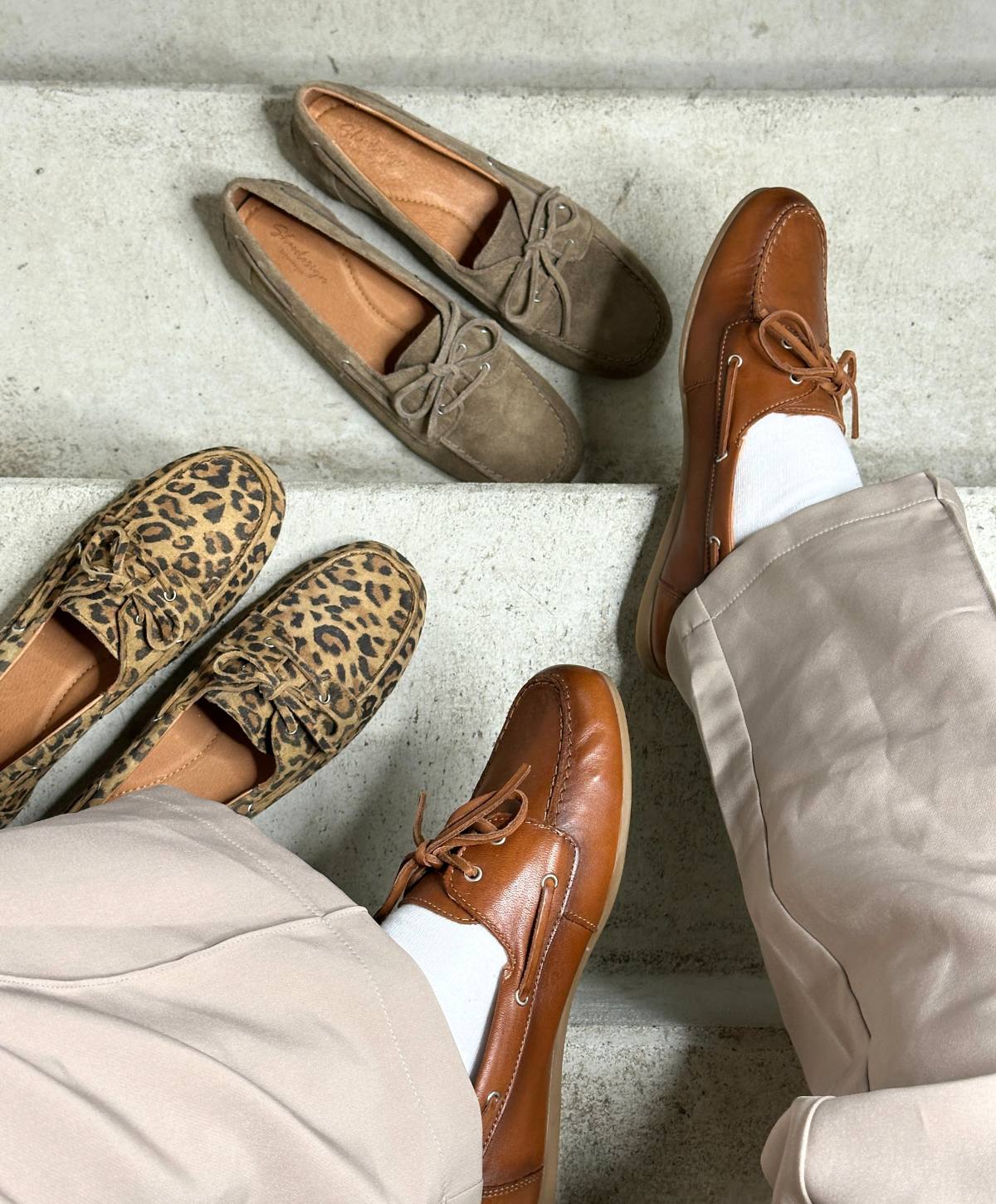 To par ben i beige bukser iført brune lædersko fra Shoedesign Copenhagen. Ved siden af er to par loafers: et i leopardmønster og et i beige ruskind, begge fra Shoedesign Copenhagen.
