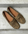 Leopardmønstrede loafers fra Shoedesign Copenhagen på en betonbaggrund.