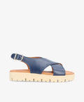 Blå lædersandal med krydsremme og justerbar spænde fra Shoedesign Copenhagen, flad sål med rillede detaljer.
